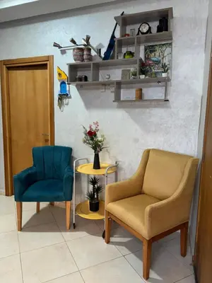 a room with two chairs and a table with flowers at Residence sables dor Mohammedia in Mohammedia