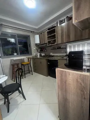 a kitchen with a stove and a table and chairs at Residence sables dor Mohammedia in Mohammedia