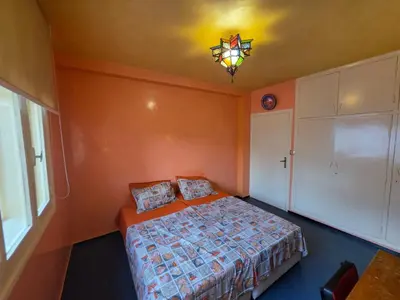 a bedroom with a bed and a chandelier at SUNSET Room in Rabat