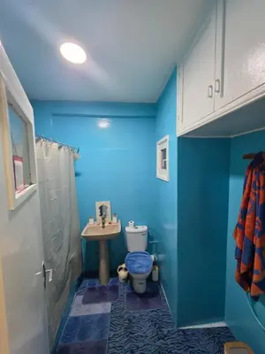 a blue bathroom with a toilet and a sink at SUNSET Room in Rabat