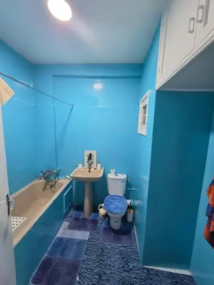 a blue bathroom with a toilet and a sink at SUNSET Room in Rabat