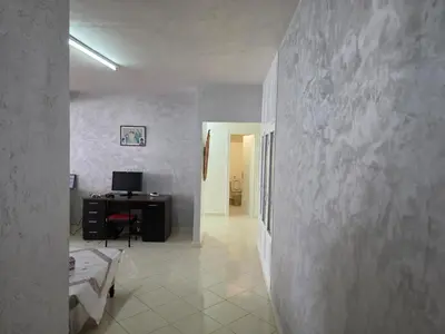 a room with a bed and a desk with a computer at SUNSET Room in Rabat