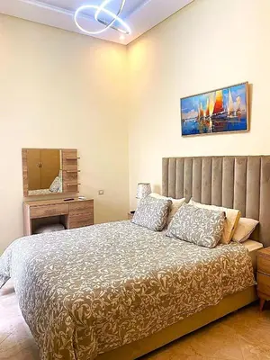 a bedroom with a bed and a desk and a mirror at Bouznika Apartement de luxe 2 Chambres RDC in Bouznika