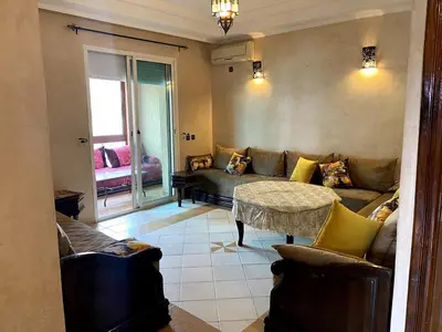 a living room with a couch and a table at Appartement a louer a mansouria rico flores in O Ben Slimane