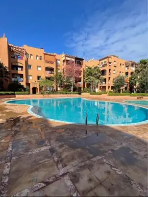 an empty swimming pool in front of a building at Appartement a louer a mansouria rico flores in O Ben Slimane