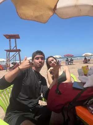 a man and a woman sitting on the beach at Résidence sara in Casablanca