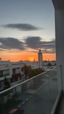 a view of a sunset from the balcony of a building at Luxueux appartement a harhoura près de la mer in Temara