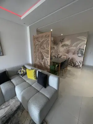 a living room with a couch and a table at Luxueux appartement a harhoura près de la mer in Temara