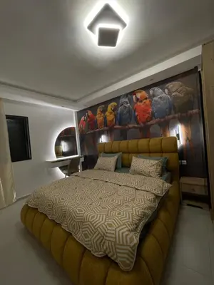 a bedroom with a bed and a painting on the wall at Luxueux appartement a harhoura près de la mer in Temara