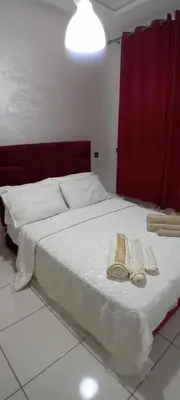 a bed with two towels and two slippers on it at Modern and comfortable apartment in mohammedia in Ben Yakhlef