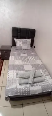 a large bed with a black headboard at Modern and comfortable apartment in mohammedia in Ben Yakhlef
