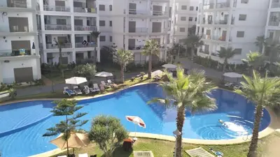 an overhead view of a swimming pool with palm trees and buildings at Grand Appartement de standing sécurisé, proche plage avec piscine privée in Bouznika