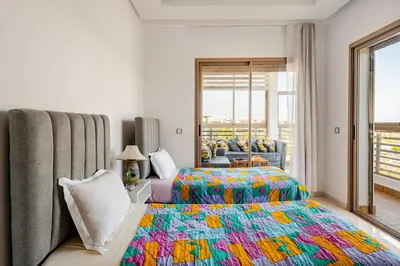 a bedroom with a bed with a colorful blanket at Grand Appartement de standing sécurisé, proche plage avec piscine privée in Bouznika