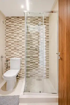 a bathroom with a toilet and a glass shower at Grand Appartement de standing sécurisé, proche plage avec piscine privée in Bouznika