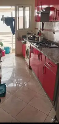 a kitchen with red cabinets and a stove at Casablanca in Bouznika