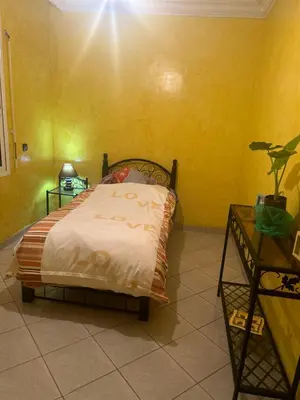a bedroom with a bed in a yellow wall at Villa Chérine in Casablanca