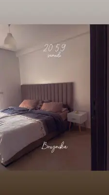 a bedroom with a bed and a side table at Appartement vu sur piscine à 5 minutes de la plage in Mansouria