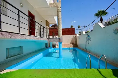 a swimming pool in the middle of a house at Appartement de Luxe - Piscine et Accès à la Plage in El Harhoura