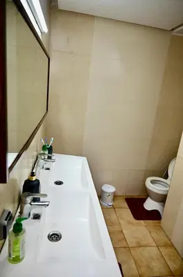a bathroom with a sink and a toilet at Appartement de Luxe - Piscine et Accès à la Plage in El Harhoura