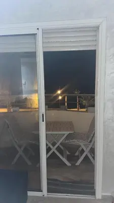 a sliding glass door with a table and chairs on a balcony at Rabat en face de océan in Rabat