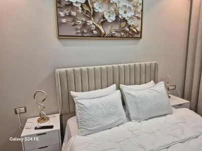 a bed with white pillows and a picture on the wall at Aeroperla Prestige Casablanca Airport in Nouaseur