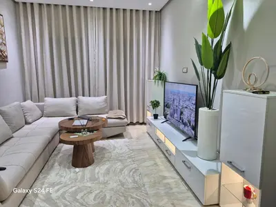a living room with a couch and a tv at Aeroperla Prestige Casablanca Airport in Nouaseur