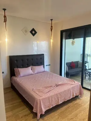 a bedroom with a large bed with a pink blanket at Relaxing Apartment Oceanic Sidi Rahal in Sidi Rahal