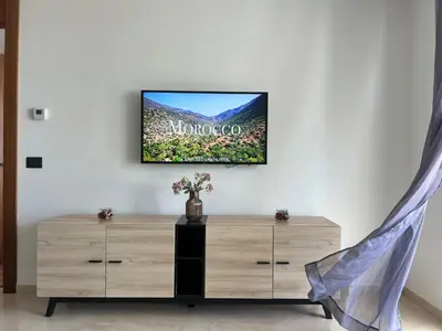 a living room with a tv on a wall at Tour 33 CFC Studio moderne & raffiné en plein cœur de Casa in Casablanca
