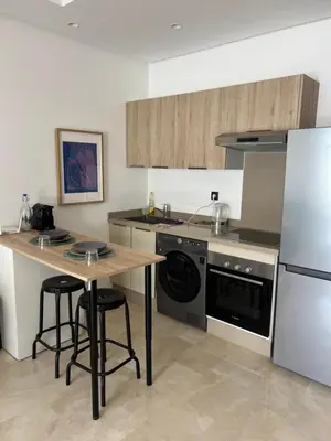 a kitchen with a table and a stove and a refrigerator at Tour 33 CFC Studio moderne & raffiné en plein cœur de Casa in Casablanca