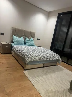 a bedroom with a bed with blue pillows on it at Superbe T2 moderne au cœur du Maarif Confort & Style in Casablanca