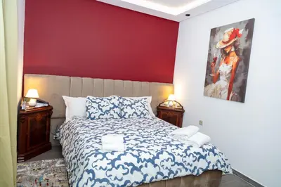 a bedroom with a bed and a red wall at Maison à Skhirat avec Jacuzzi et Jardin privé in Skhirat