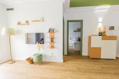 a living room with white walls and wooden floors at Casa JOY in Casablanca