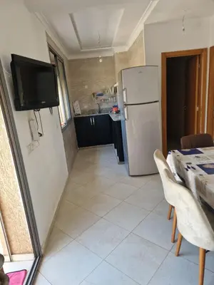 a kitchen with a white refrigerator and a table with chairs at Sable d'or in O Ben Slimane