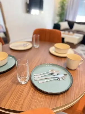a wooden table with plates and silverware on it at Cosy Modern Retreat in Casablanca in Casablanca