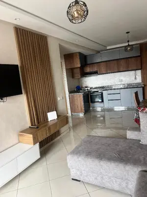 a living room with a couch and a tv in it at Casablanca luxury Studio in Casablanca