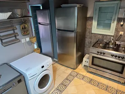 a kitchen with a refrigerator and a washing machine at beachfront house frond de mer in Skhirat
