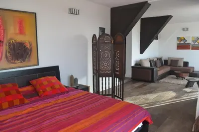 a bedroom with a bed and a living room at beachfront house frond de mer in Skhirat