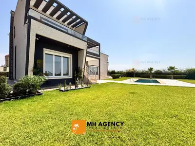 a house with a lawn in front of it at Oliveraie - Villa Benslimane in O Ben Slimane