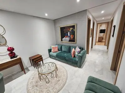 a living room with a green couch and a table at Prestigia Luxury and Serenity in Rabat