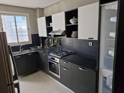 a kitchen with white cabinets and a stove top oven at Prestigia Luxury and Serenity in Rabat