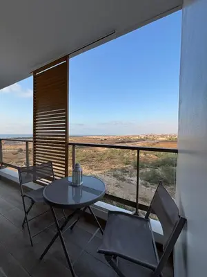a table and chairs on a balcony with a view at Cosy 2 chambres - Clim & Parking in Casablanca