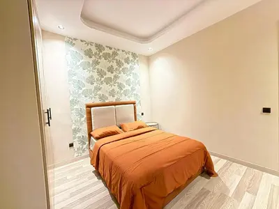 a bedroom with a bed with an orange blanket at Studio Élégant et Moderne a Maarif, Casablanca in Casablanca