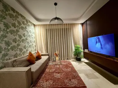 a living room with a couch and a flat screen tv at Studio Élégant et Moderne a Maarif, Casablanca in Casablanca