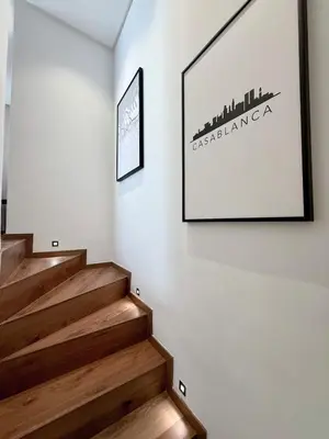 a staircase with a picture on the wall at Luxurious Boho-Styled Duplex - Rooftop Sky Pool in Casablanca