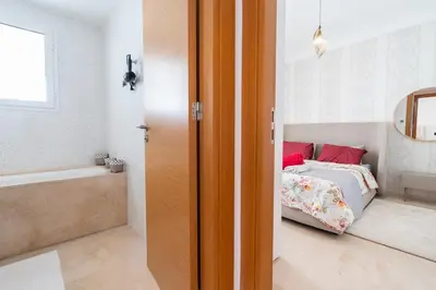 a bedroom with a bed and a bath tub at Elegant Family Unit with Pool & Gym Casa Finance City m2a in Casablanca