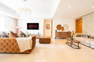 a living room with a couch and a table at Elegant Family Unit with Pool & Gym Casa Finance City m2a in Casablanca