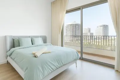 a white bedroom with a bed and a large window at Kridarek - Appartement chic et cosy à Casa Finance City in Casablanca