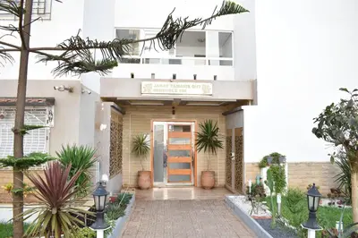 a building with a sign on the front of it at Kridarek - Bel appartement avec piscine à Dar Bouazza in Tamaris