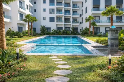 a swimming pool in front of a building at Affordable Luxury Apartment in Nouaseur