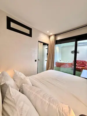 a bedroom with a large white bed and a window at App Chic & Jacuzzi à Bourgogne près de la Corniche in Casablanca-Port